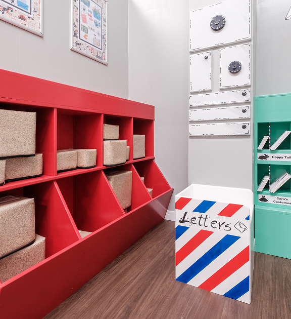 News. A Role Play setting of a post office with a red parcel sorting station and a stripped area for letters.